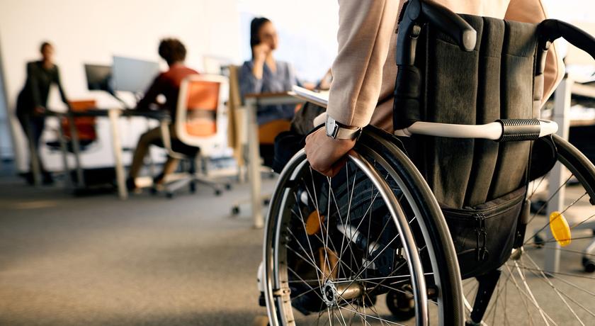 Treballador en una oficina amb cadira de rodes